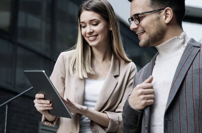 Two people looking at an ERP system on a tablet.